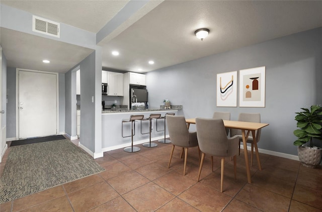 dining room with tile patterned flooring and a textured ceiling