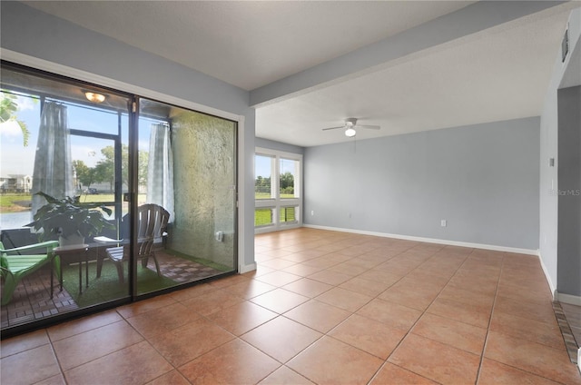 spare room featuring tile patterned flooring, baseboards, and a ceiling fan