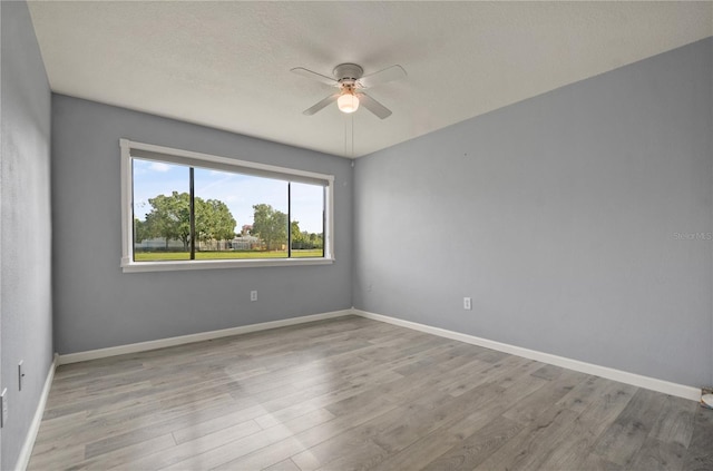 unfurnished room featuring ceiling fan, a textured ceiling, baseboards, and wood finished floors