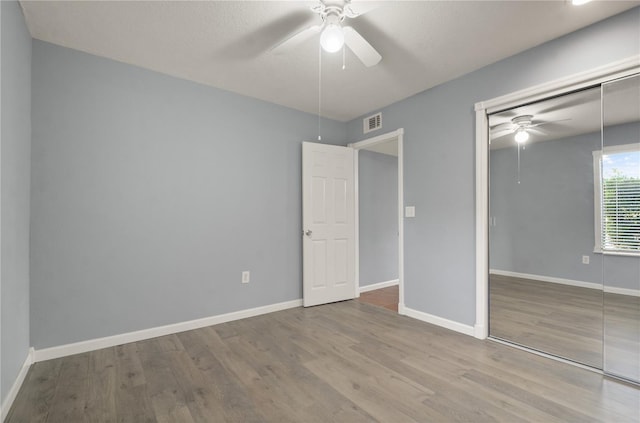 unfurnished bedroom featuring a closet, baseboards, and wood finished floors