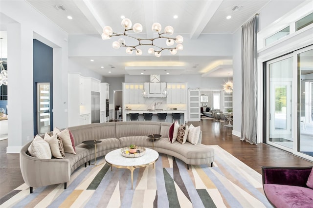 living room with dark wood-type flooring, beamed ceiling, sink, and a chandelier