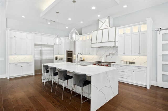 kitchen featuring a large island, dark hardwood / wood-style floors, white cabinetry, and a barn door