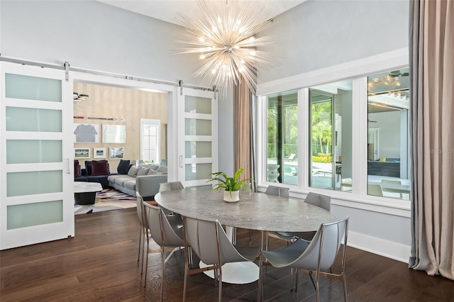 dining room with an inviting chandelier, dark hardwood / wood-style flooring, and a barn door