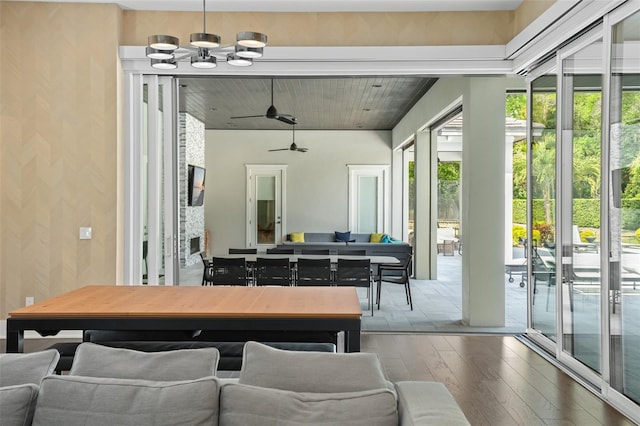 rec room featuring wood-type flooring and ceiling fan with notable chandelier