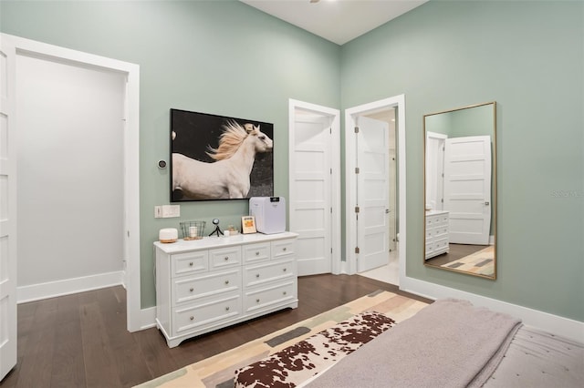 bedroom with ensuite bath and dark hardwood / wood-style flooring