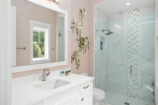 bathroom with vanity, a shower with shower door, and toilet