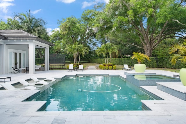 view of swimming pool featuring an in ground hot tub and a patio