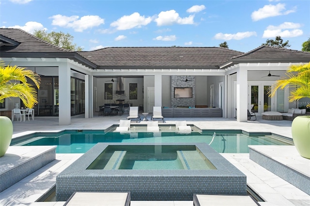 rear view of property featuring french doors, a swimming pool with hot tub, an outdoor living space, a patio, and ceiling fan