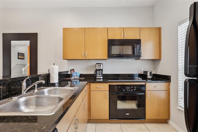 kitchen with light tile patterned flooring, sink, a wealth of natural light, and black appliances