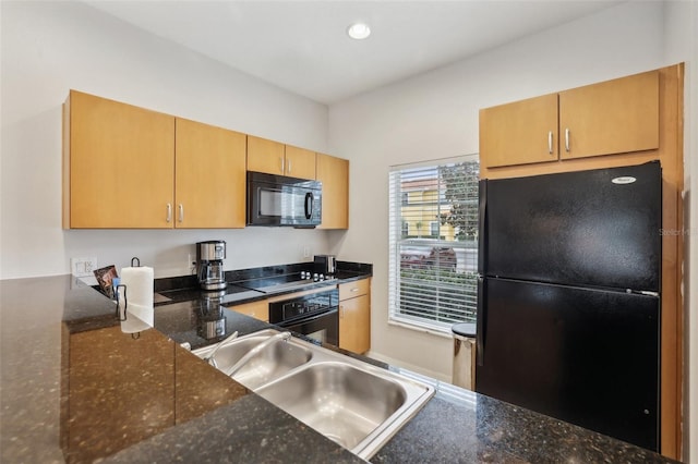 kitchen with dark stone counters, sink, black appliances, and light brown cabinets