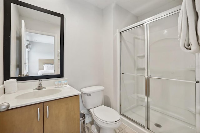 bathroom featuring tile patterned flooring, vanity, toilet, and a shower with door