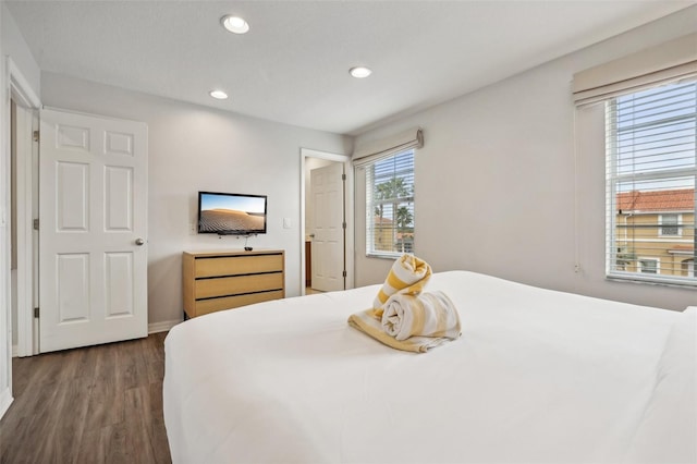 bedroom featuring multiple windows and dark wood-type flooring