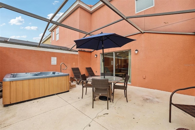 view of patio / terrace featuring a lanai and a hot tub