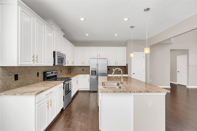 kitchen featuring appliances with stainless steel finishes, dark hardwood / wood-style flooring, a center island with sink, and hanging light fixtures