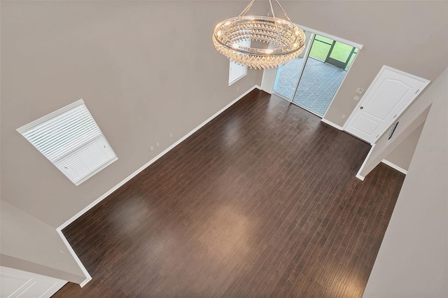 interior space with dark wood-type flooring and a chandelier