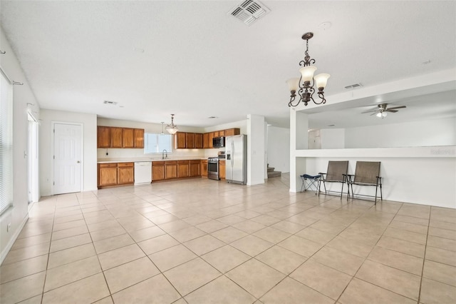 unfurnished living room with sink, light tile patterned flooring, and ceiling fan with notable chandelier