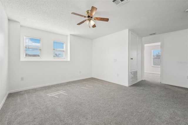 spare room with ceiling fan, a textured ceiling, and carpet floors