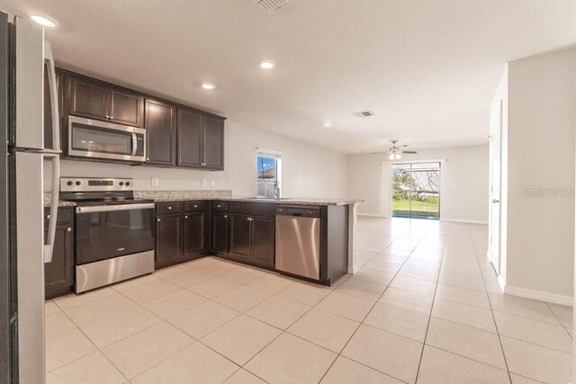 kitchen with dark brown cabinetry, kitchen peninsula, stainless steel appliances, and ceiling fan