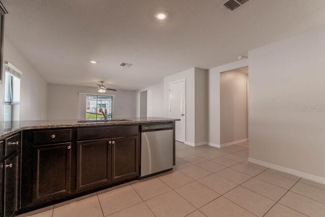 kitchen with ceiling fan, light tile patterned floors, stainless steel dishwasher, dark stone countertops, and sink