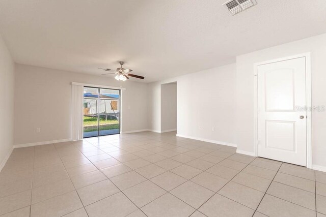 empty room with ceiling fan and light tile patterned floors