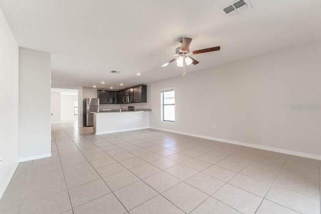 unfurnished living room featuring ceiling fan and light tile patterned floors