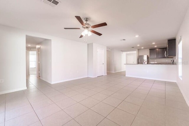 unfurnished living room with light tile patterned floors and ceiling fan