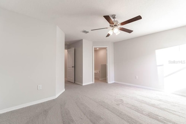 spare room featuring light carpet and ceiling fan