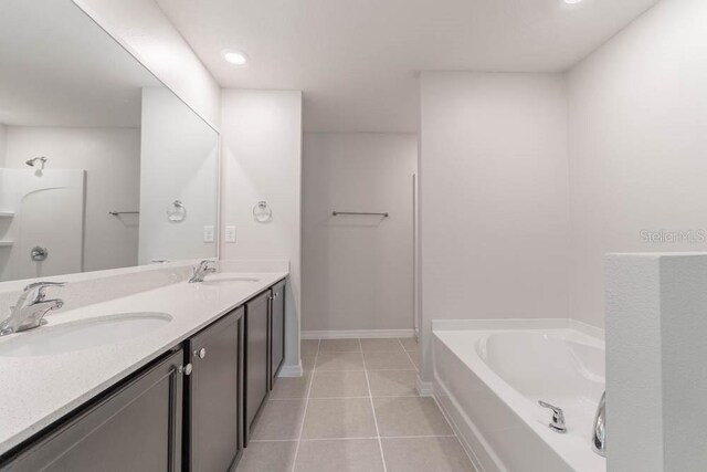 bathroom with vanity, a bathtub, and tile patterned flooring