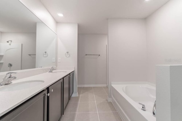 207 Goldenrod Ln, Kissimmee, FL 34759 - bathroom with a garden tub, double vanity, tile patterned floors, and baseboards