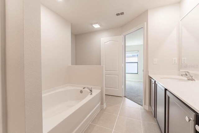 bathroom with vanity, a bathtub, and tile patterned flooring