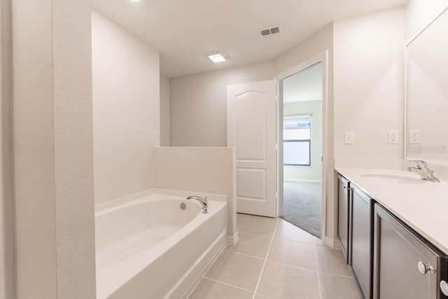 207 Goldenrod Ln, Kissimmee, FL 34759 - bathroom featuring tile patterned flooring, vanity, a garden tub, and baseboards