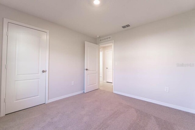 unfurnished bedroom featuring light carpet