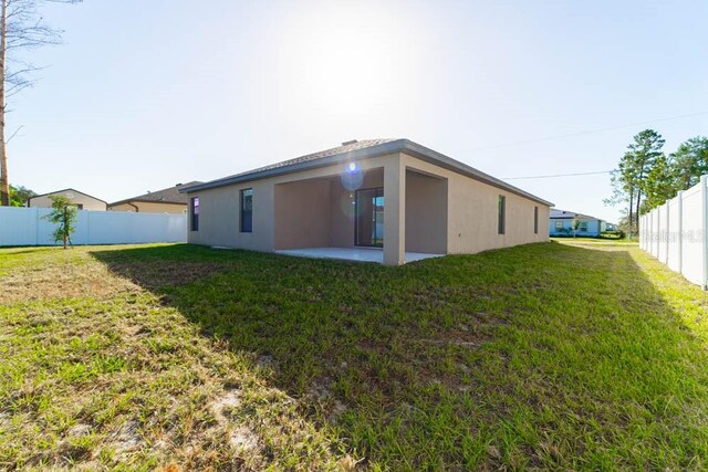 back of house featuring a patio and a lawn