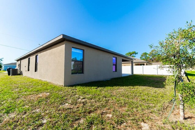 view of home's exterior with a yard and central AC