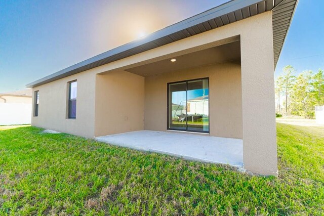 207 Goldenrod Ln, Kissimmee, FL 34759 - back of property with stucco siding, a yard, and a patio area