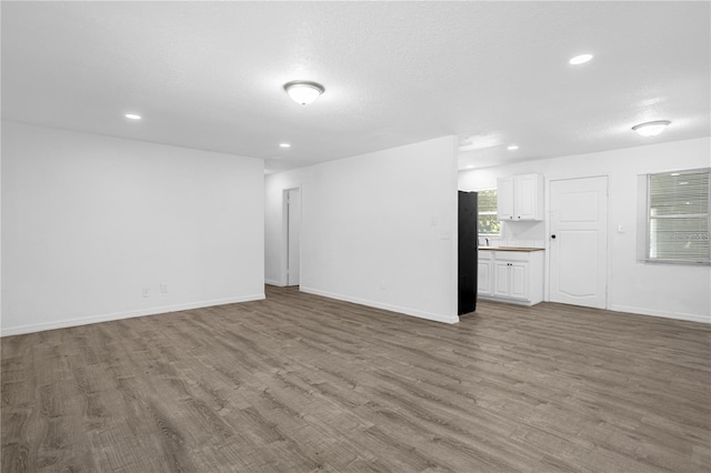 unfurnished living room with a textured ceiling and hardwood / wood-style flooring