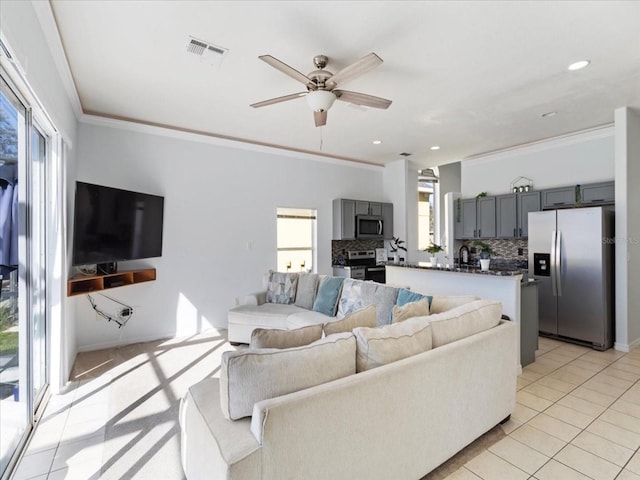 tiled living room featuring ceiling fan, ornamental molding, and sink