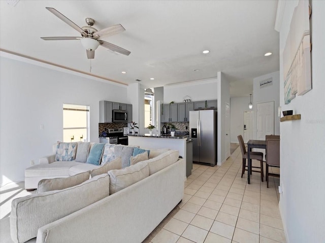 living room featuring ceiling fan, ornamental molding, and light tile patterned flooring