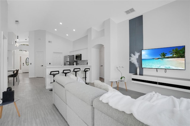 living room with an inviting chandelier and high vaulted ceiling