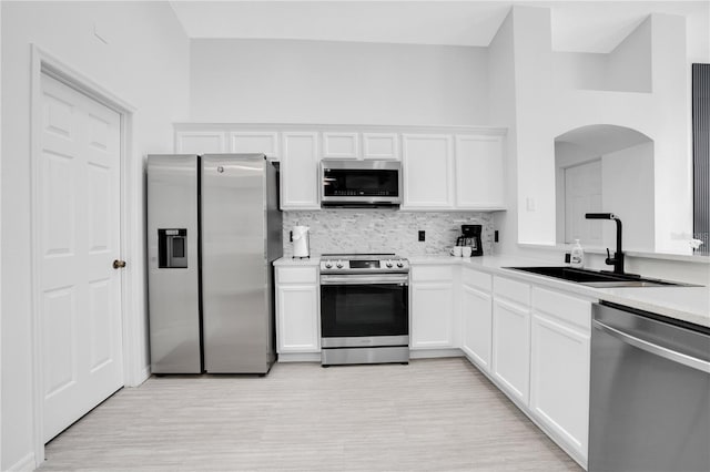 kitchen featuring sink, decorative backsplash, white cabinetry, and stainless steel appliances