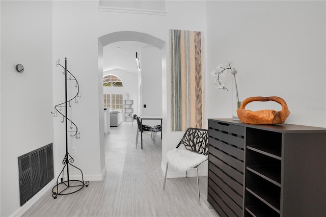 hallway featuring lofted ceiling and hardwood / wood-style floors