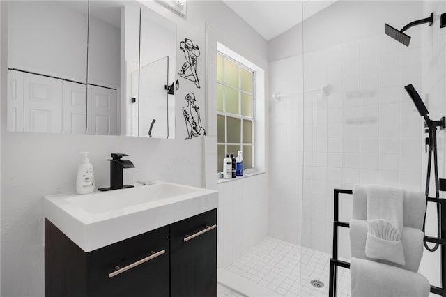 bathroom featuring vanity, lofted ceiling, and tiled shower