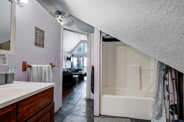 bathroom with vanity, shower / bathtub combination with curtain, and vaulted ceiling