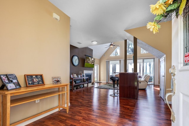 living room with ceiling fan, dark hardwood / wood-style flooring, and vaulted ceiling