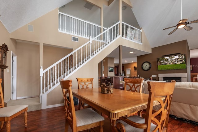 dining space with a high ceiling, a textured ceiling, dark hardwood / wood-style floors, and ceiling fan