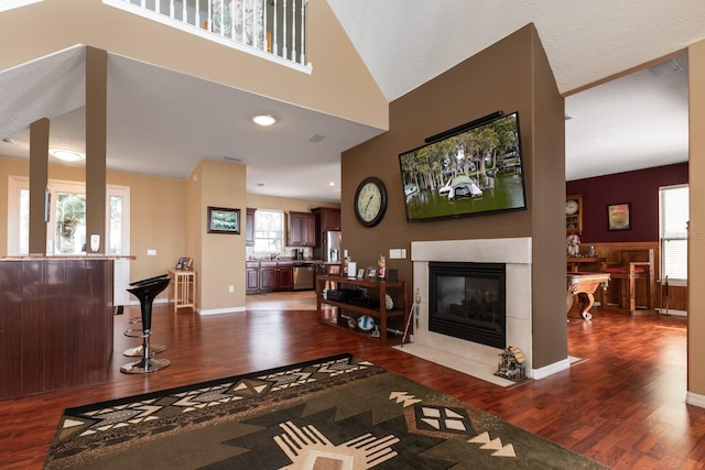 living room featuring a tile fireplace, hardwood / wood-style floors, and plenty of natural light