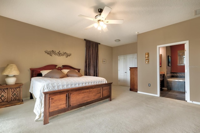 bedroom featuring connected bathroom, ceiling fan, a closet, and light colored carpet