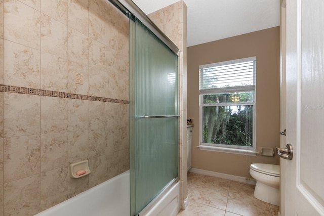 bathroom featuring tile patterned flooring, enclosed tub / shower combo, and toilet