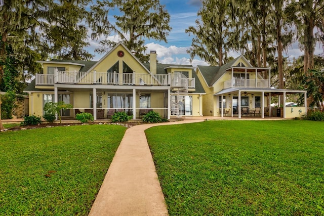 back of house with a balcony and a yard