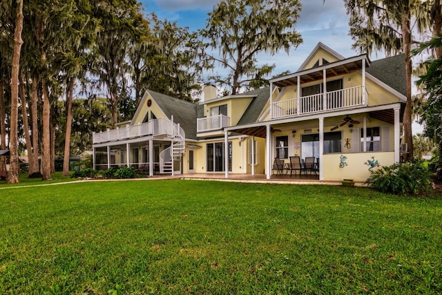 back of house with a balcony, a yard, and a patio